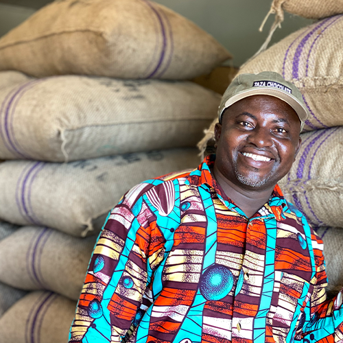 Stephen Ashia in front of sacks of dried cocoa at the LBC warehouse in Suhum